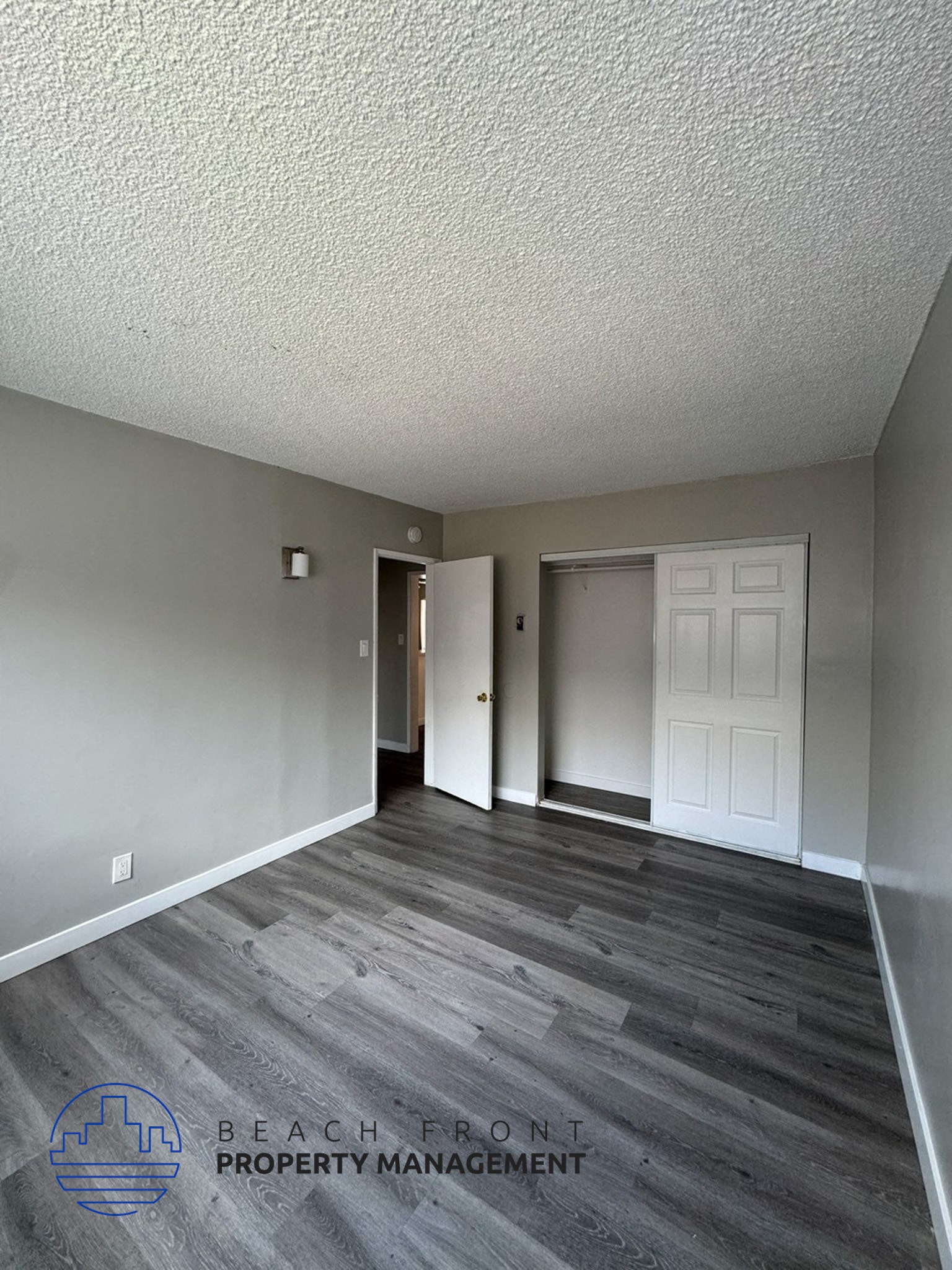 an empty living room with wood floors and a white door